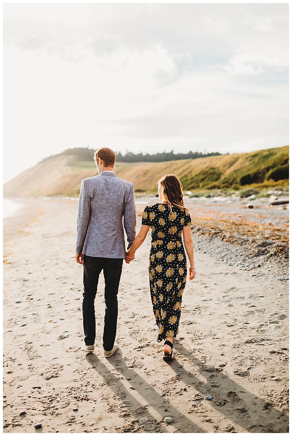 couple walking hand in hand down quiet beach