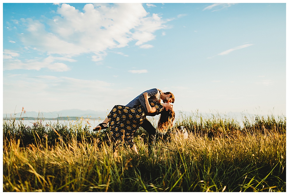 couple kiss passionately in grassy field
