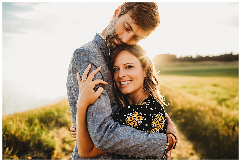 young couple hug during outdoor engagement photoshoot