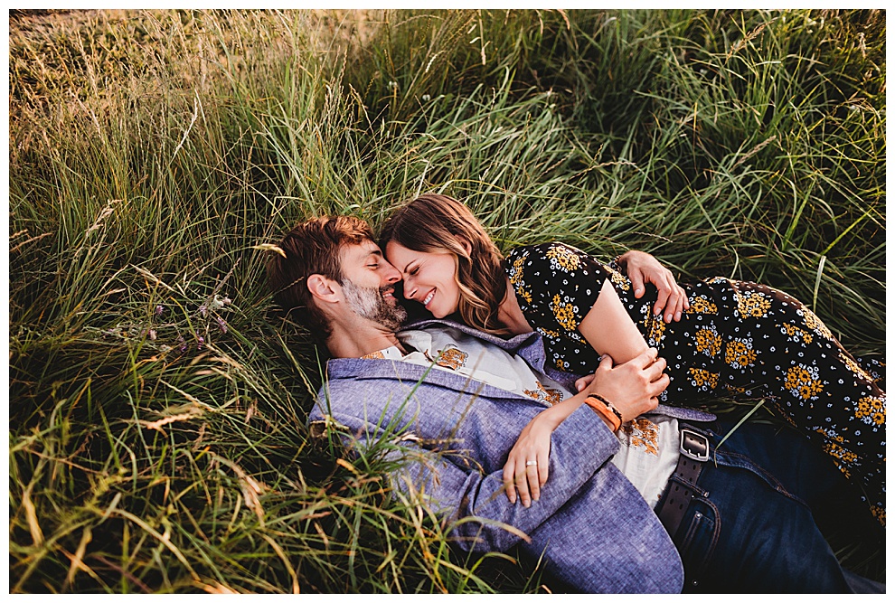 man and woman laughing lying in grass