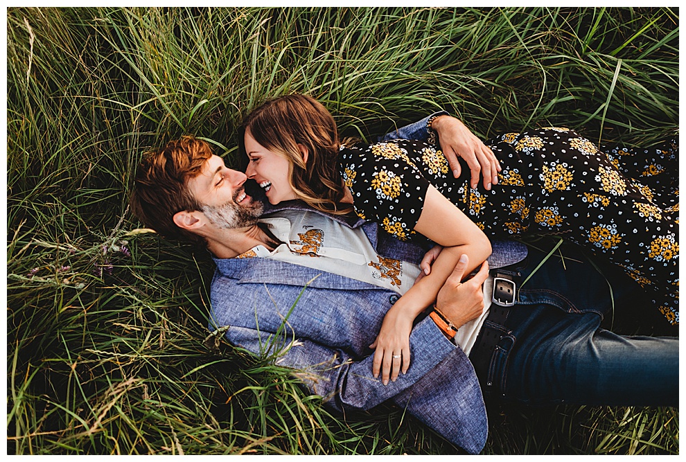 couple lying in grass, hugging and laughing