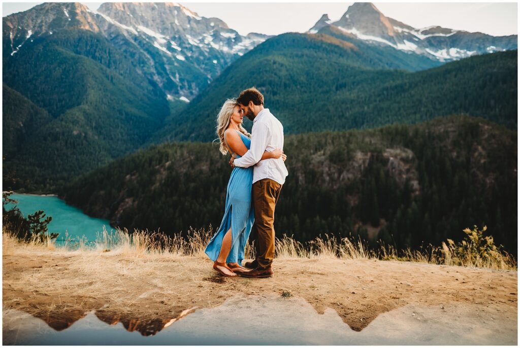 Couple on a mountain getting engagement photos taken