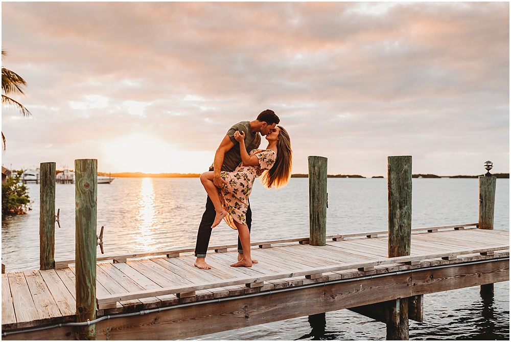 couple shares a kiss on a dock